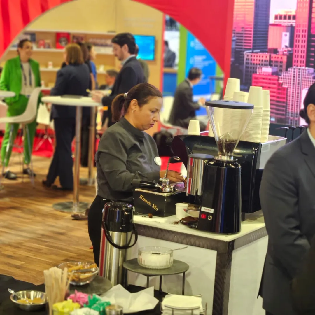 Barista serving espresso at a branded booth